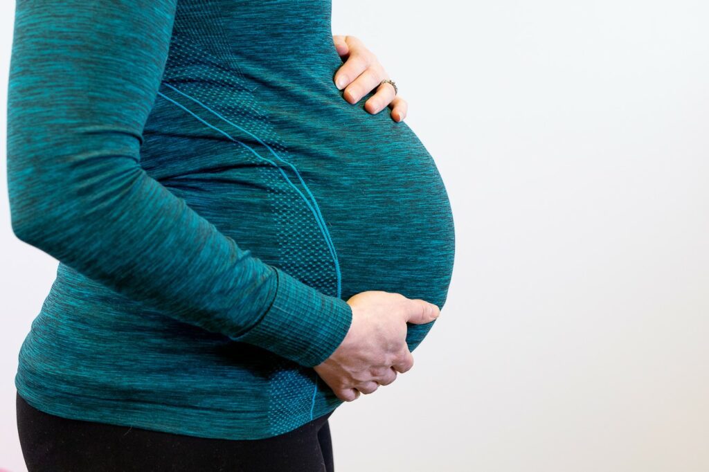 Nainen pitelee raskausvatsaansa. Keho kuntoon MAMA -valmennus tukee hyvinvointiasi raskausaikana.